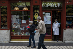 Varias personas salen de comprar en una farmacia de Madrid.