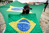 AME1058. BRASILIA ( lt;HIT gt;BRASIL lt;/HIT gt;).- Una mujer sostiene una bandera de lt;HIT gt;Brasil lt;/HIT gt; con cruces negras pintadas por las vctimas de covid-19 en ese pas, durante una protesta contra el presidente de lt;HIT gt;Brasil lt;/HIT gt;, Jair Bolsonaro, este mircoles, en el Palacio de Planalto en Brasilia ( lt;HIT gt;Brasil lt;/HIT gt;). Convocados por los miembros del comit popular "Fuera Bolsonaro", decenas de personas participaron en la manifestacin que rechaza las declaraciones y las acciones por parte de Bolsonaro durante el manejo de la crisis por coronavirus, que deja ms de 17.000 muertes en el pas sudamericano.
