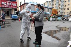 Un sanitario toma la temperatura a una mujer en Jilin, China, tras el brote de coronavirus.