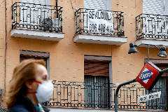 Una mujer camina delante de un piso en alquiler en Madrid, durante la cuarentena.