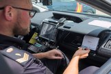 Un oficial de la Polica Nacional comprueba la identidad de un ciudadano desde un vehculo conectado.