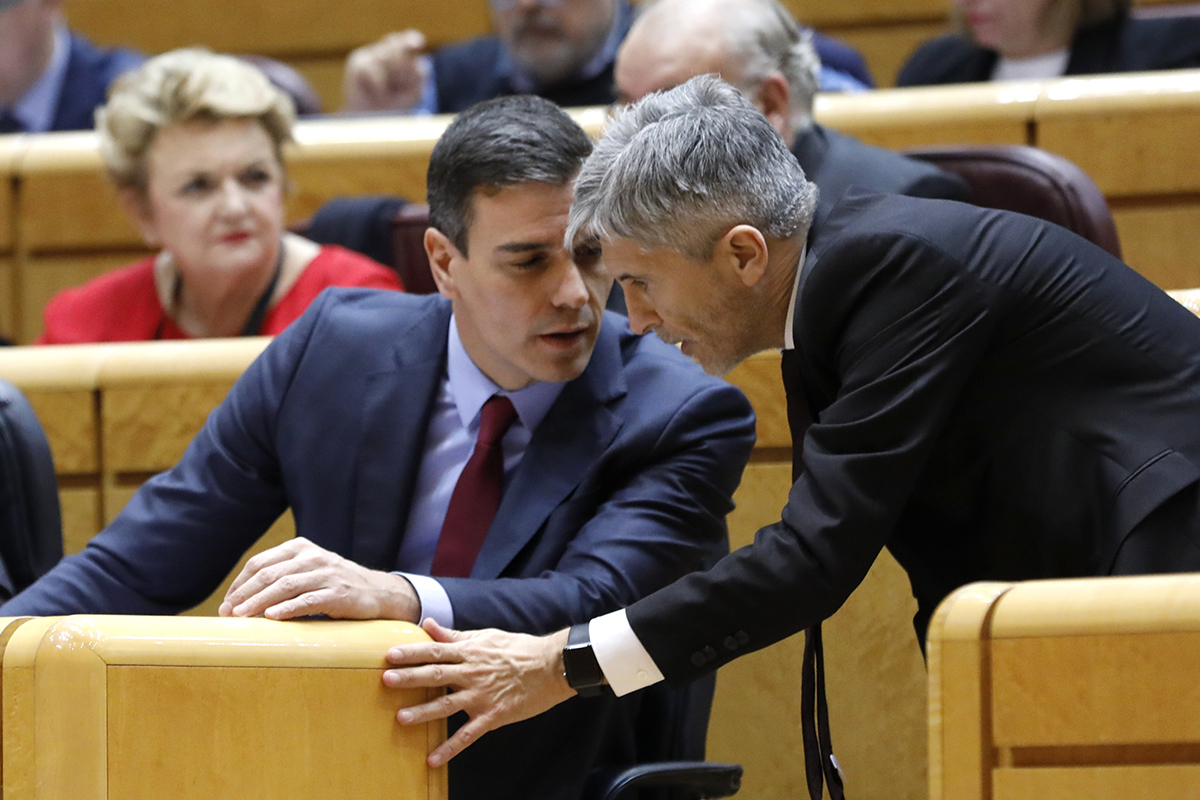 El ministro Fernando Grande-Marlaska (dcha.) habla con el presidente, Pedro Sánchez, en el Senado.