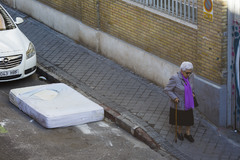 Una mujer pasa frente a un colchn abandonado.