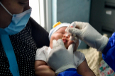 Una mujer indonesa carga en sus brazos a su beb, que recibe una dosis oral de la vacuna.