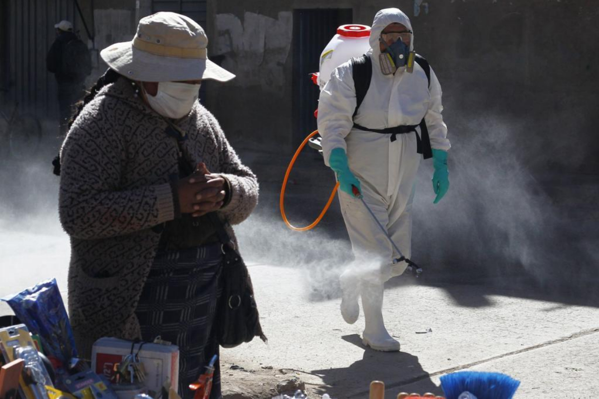 Un hombre fumiga un mercado en Puno.