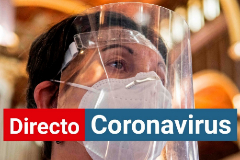 Una mujer se protege del coronavirus con una mascarilla y una pantalla.