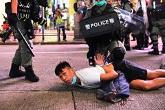Varios policas detienen a un manifestante durante una protesta en Hong Kong.