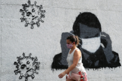Una mujer en Ro de Janeiro pasa junto a un graffiti de Jair Bolsonaro