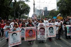A relative of a missing student holds a poster with the image of Christian Alfonso Rodriguez Telumbre during a march in Mexico City