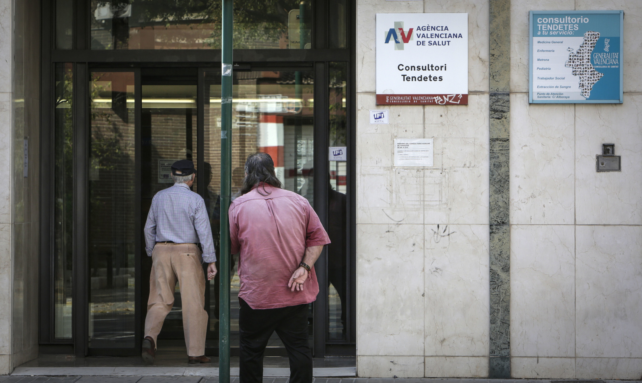 Dos hombres acceden a un centro de salud en Valencia.