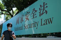 Un hombre cruza frente a un cartel del Gobierno que anuncia la nueva Ley de Seguridad Nacional en Hong Kong.