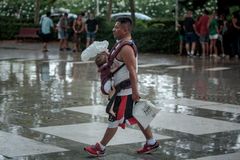 Un hombre protege a un beb de la lluvia, en Valencia, en una imagen del pasado 14 de julio.