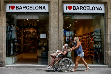 Dos personas pasan ante una tienda de recuerdos de la Rambla de Barcelona.