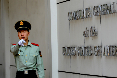 Un polica chino se dirige a los fotgrafos en la entrada del consulado de EEUU en Chengdu.