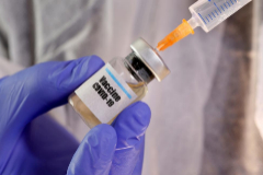 Una sanitaria sostiene una de las vacunas que se ensayan