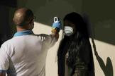 Un sanitario le toma la temperatura a una mujer en el barrio madrileo de Carabanchel