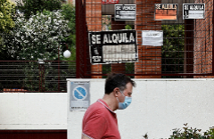 Un ciudadano pasea por delante de una fachada repleta de carteles de 'Se alquila', en Madrid.