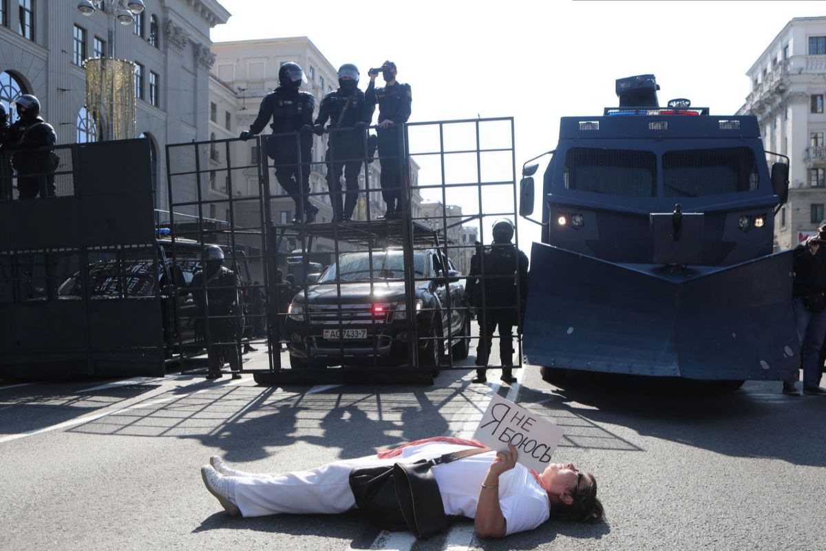 Una mujer, tendida frente a las fuerzas de seguridad con un cartel que dice "No tengo miedo".