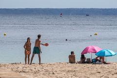 Varias personas disfrutan de una jornada de playa en Mallora.