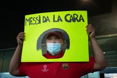 Un hincha del Bara muestra un cartel con un mensaje para Messi.