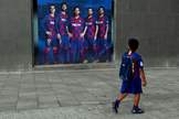 Un nio mira un pster promocional del Bara con Messi.