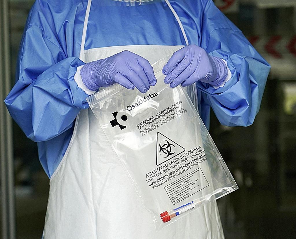 Un sanitario protegido con guantes sostiene una bolsa en la que hay una muestra para realizar un Anlisis PCR
