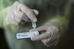 Un profesional sanitario maneja una prueba rpida para detectar coronavirus.