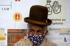 Una votante junto a un cartel con las reglas antiCovid, en La Paz.