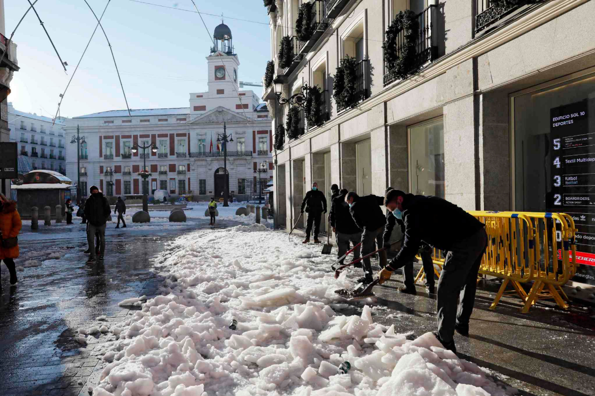 Empleados de El Corte Ingls limpian el acceso a una tienda, en el entorno de la Puerta del Sol.
