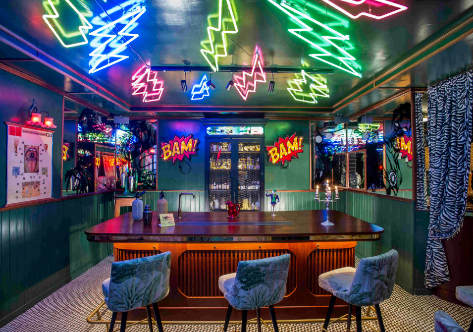 Interior de Salmon Guru, con neones de estilo pop.