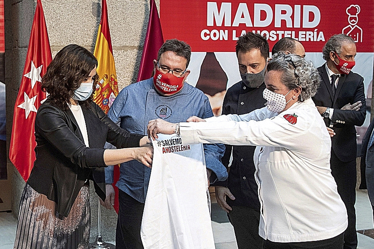 La chef Pepa Muoz entrega un delantal a la presidenta de la Comunidad de Madrid, Isabel Daz Ayuso