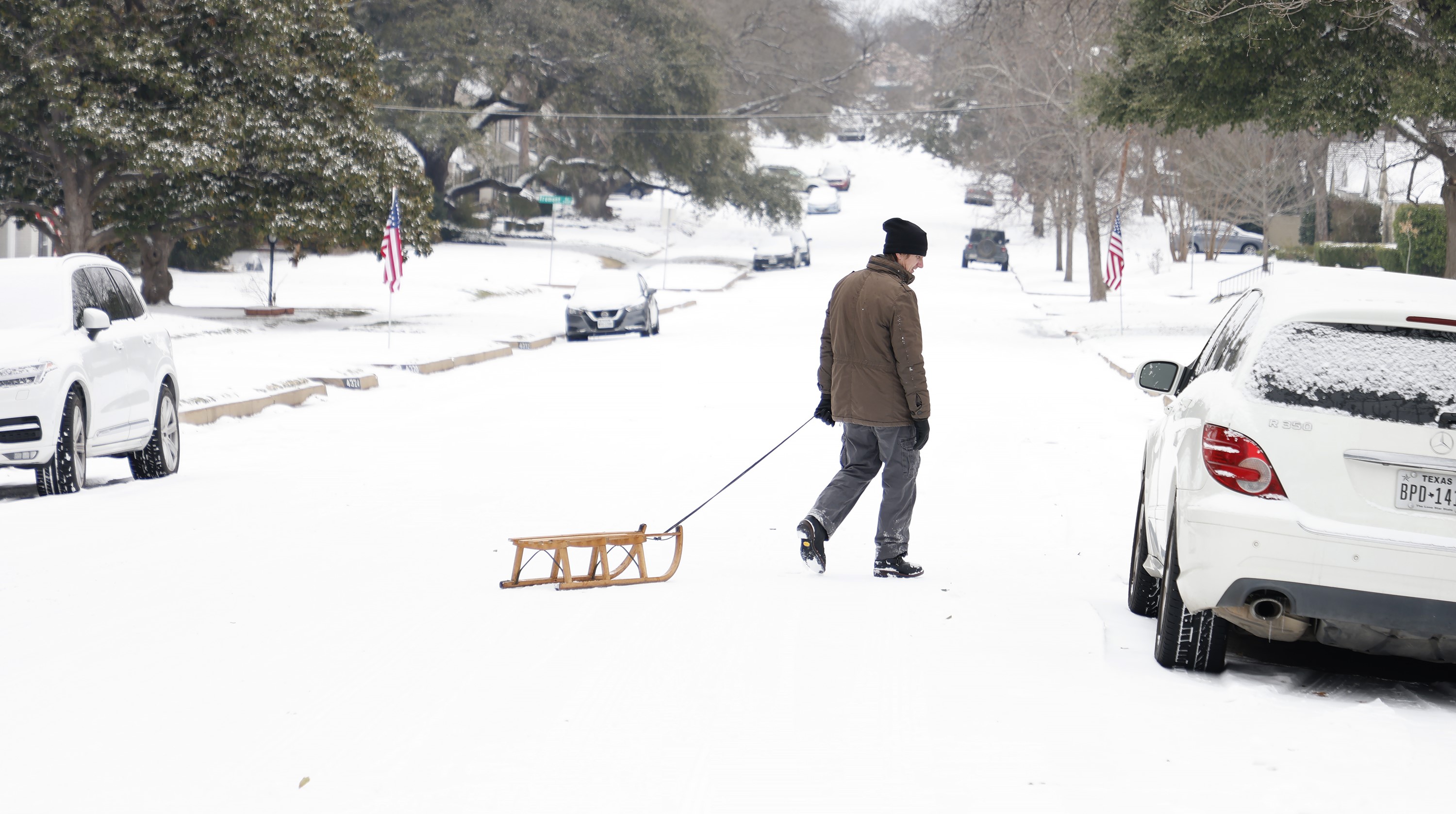 Un hombre pasea por las calles de Austin tirando de un trineo.