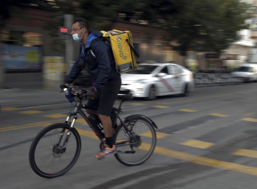 Un repartidor de Glovo se dirige a una entrega por las calles de Madrid.