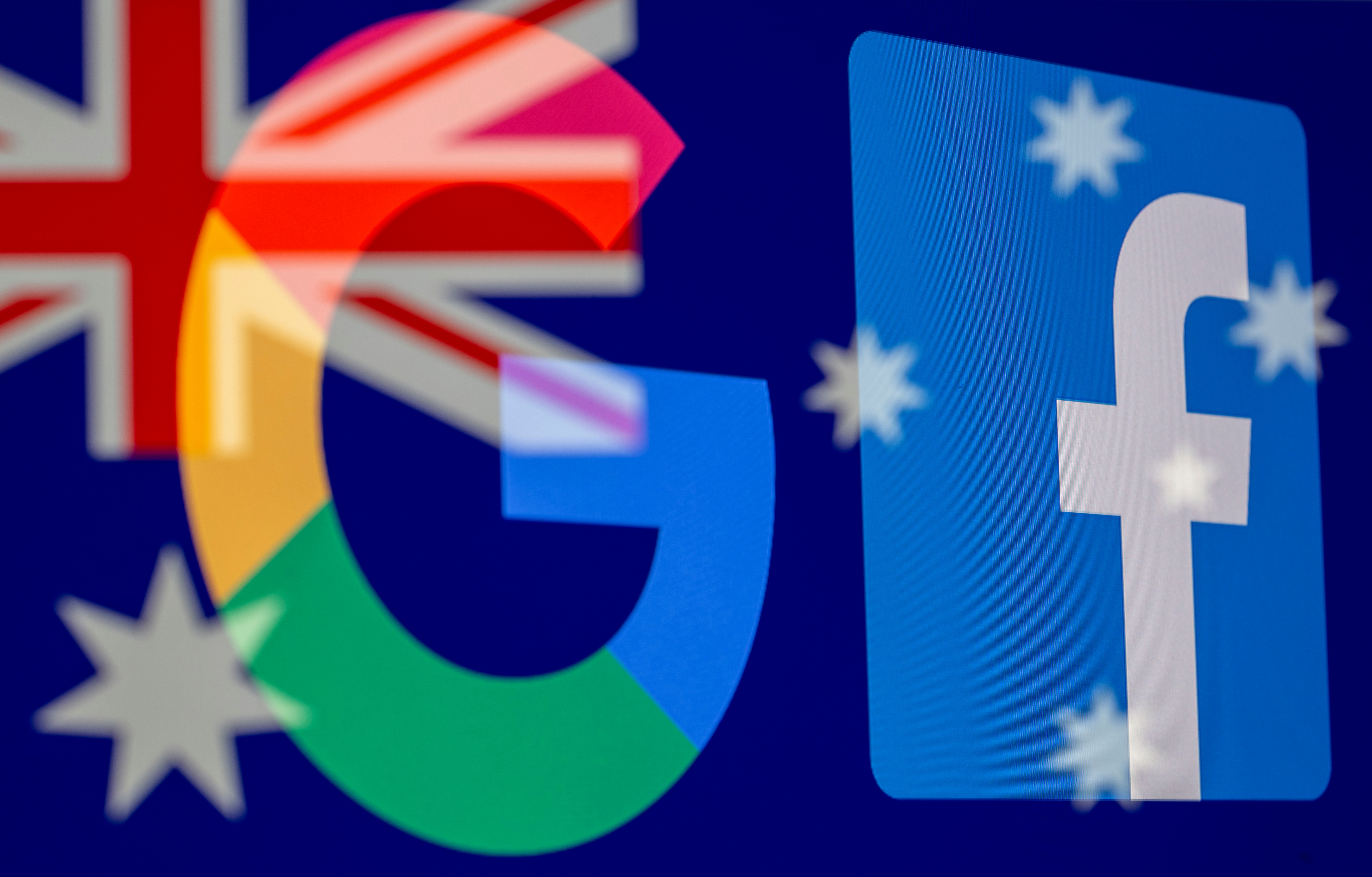 Los logos de Google y Facebook reflejados sobre una bandera australiana.