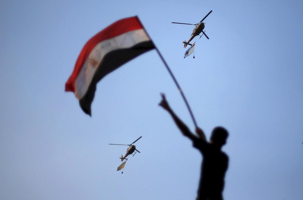 Helicpteros militares con banderas egipcias sobrevuelan la plaza de Tahrir, durante las protestas de 2011