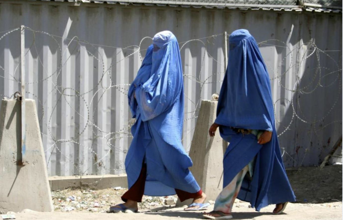 Dos mujeres afganas vestidas con el tradicional burka caminan frente a la embajada de Reino Unido en Kabul.
