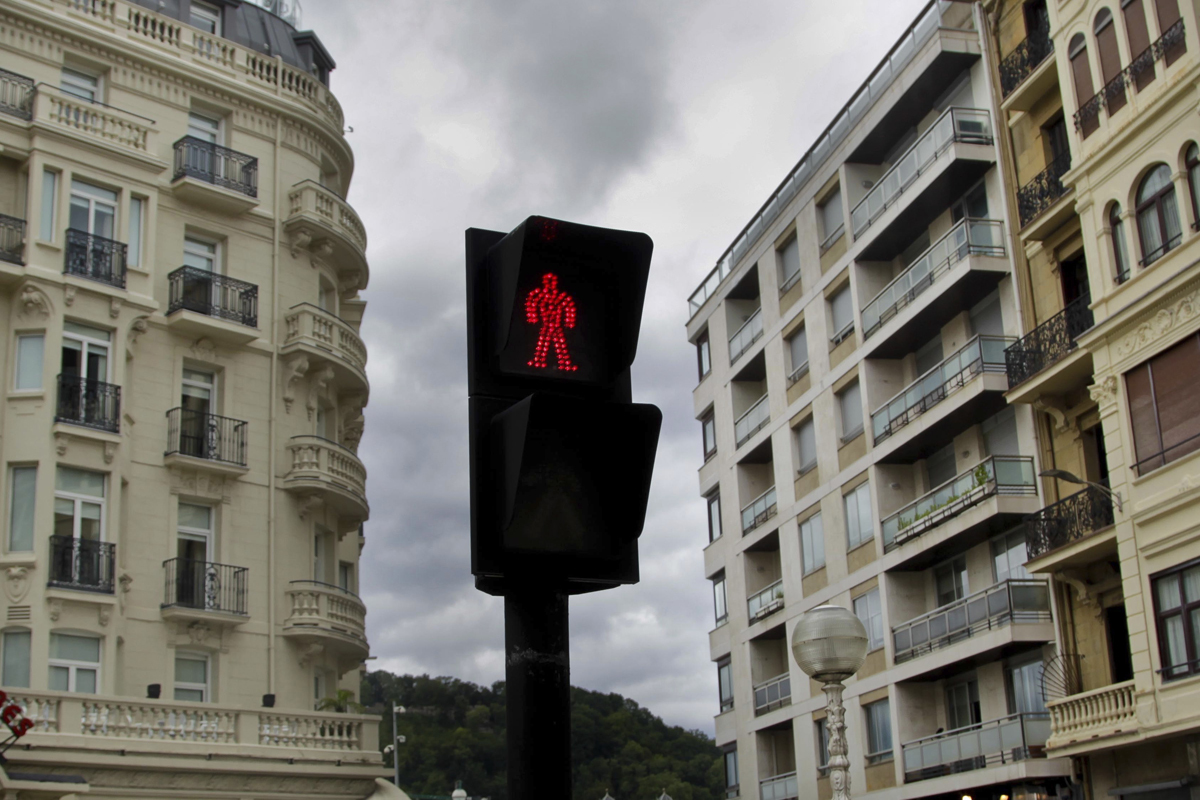 Un semforo en rojo para peatones ante varios edificios de San Sebastin.