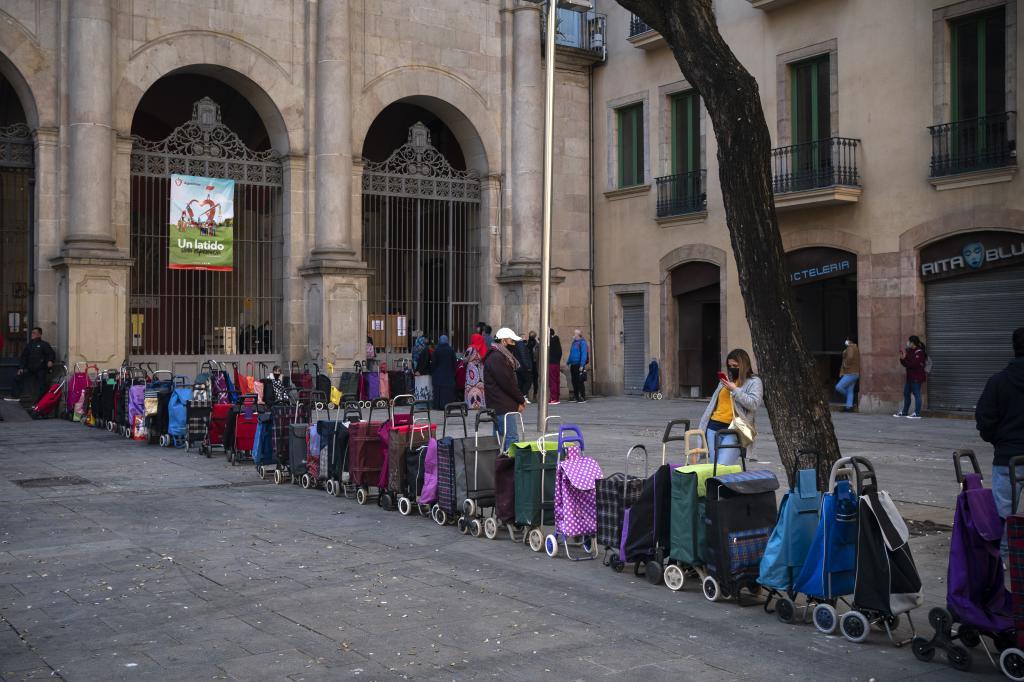 Carritos de compra en fila a las puertas de una Iglesia que reparte alimentos en Barcelona  el pasado 24 de marzo.