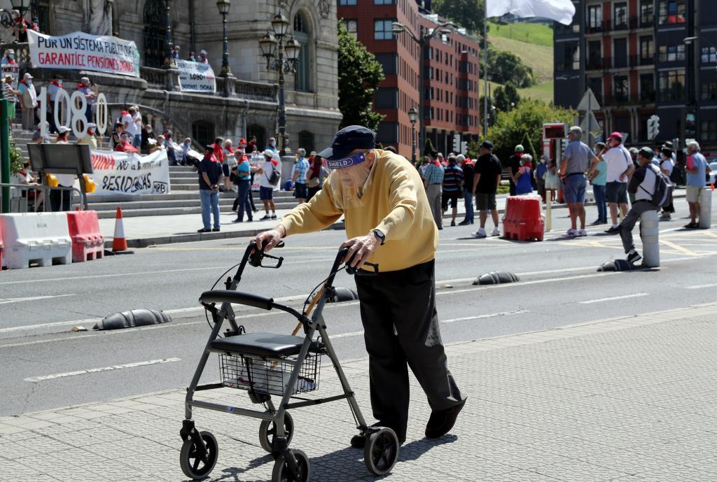 Un jubilado camina en Bilbao ante una concentracin del movimiento de pensionistas de Bizkaia.