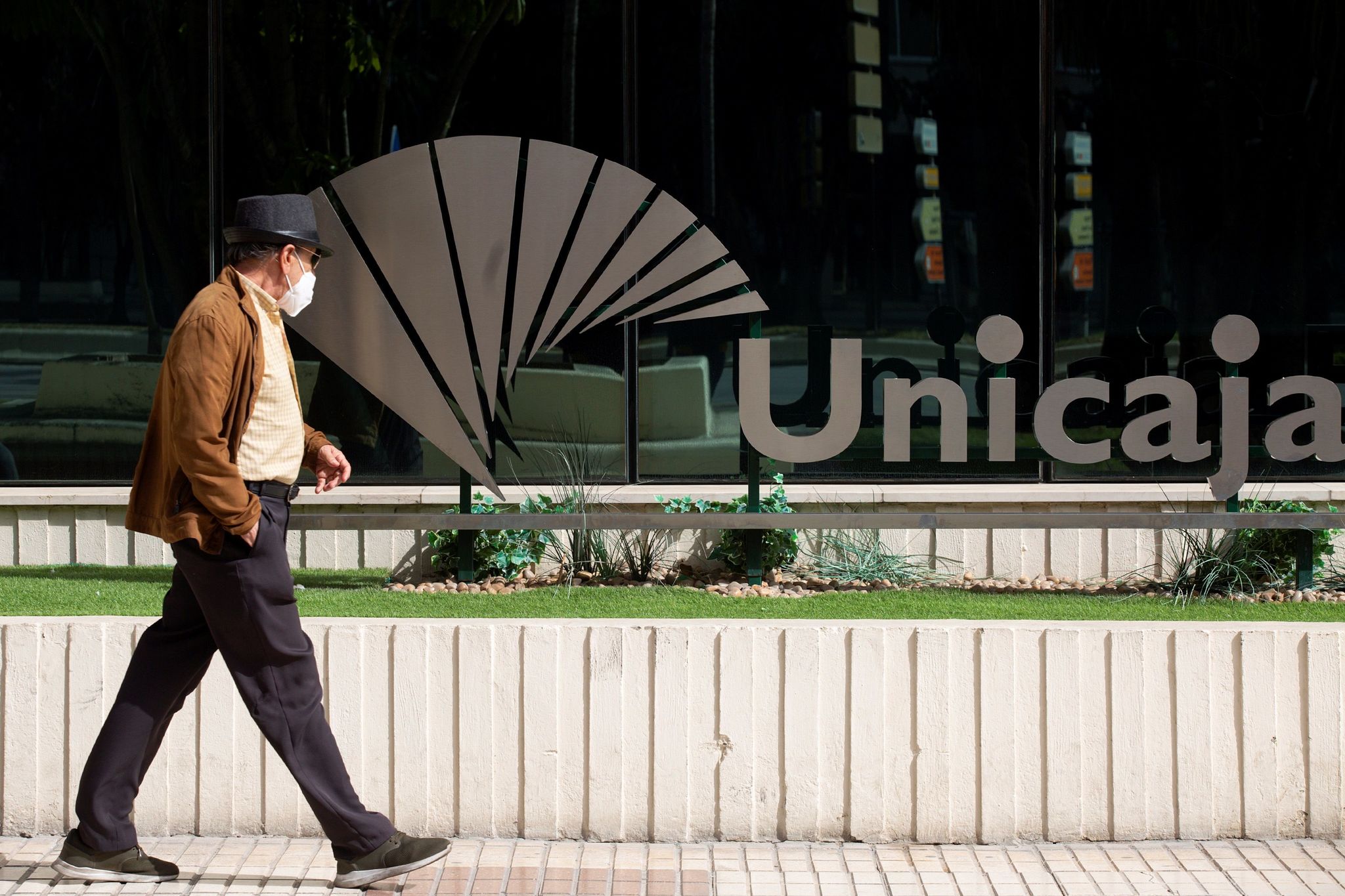 Un hombre pasea frente a la sede central de Unicaja, en Mlaga.