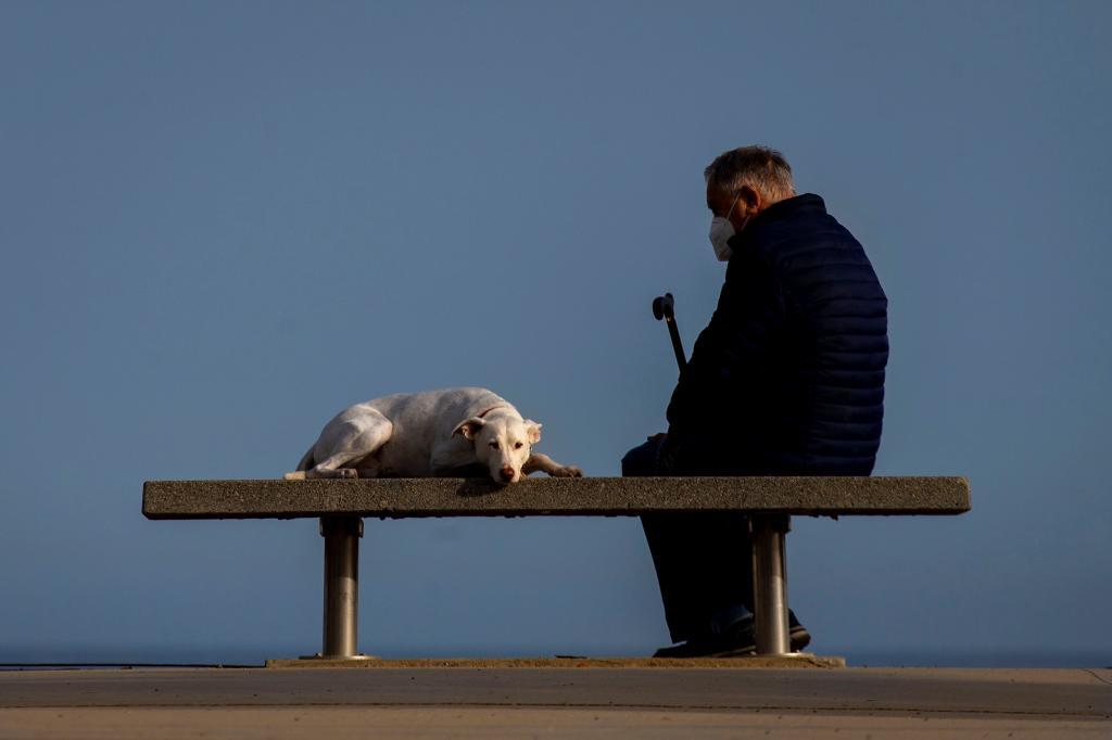 Un hombre descansa con su perro en Barcelona.