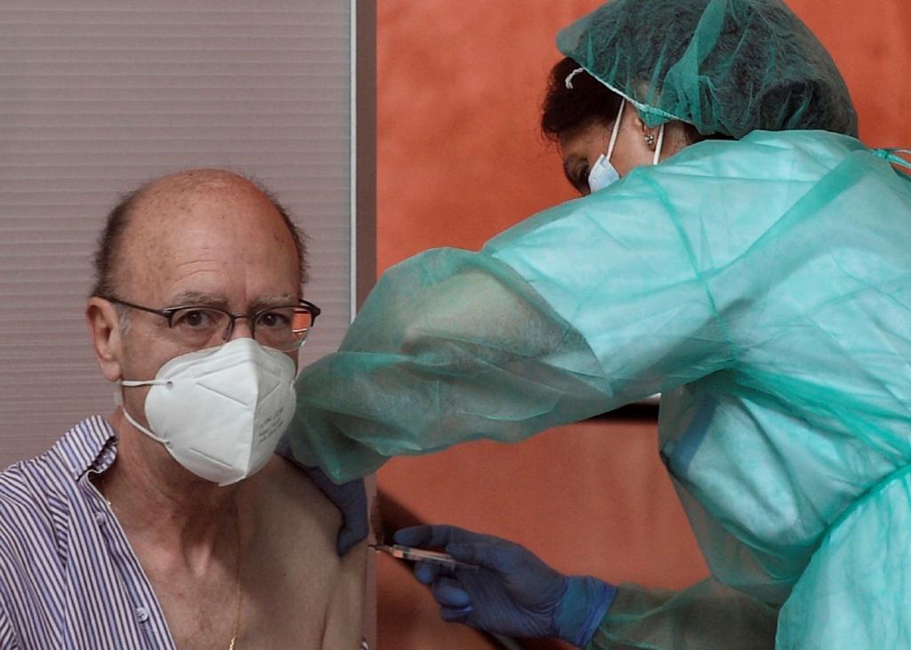 Una sanitaria vacuna a un ciudadano en Valladolid después de que se retomara la vacunación con AstraZeneca.