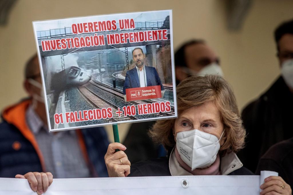 Una mujer sostiene una pancarta a las puerta del TSJ de Madrid en una protesta de la Asociación Plataforma Víctimas Alvia 04155.