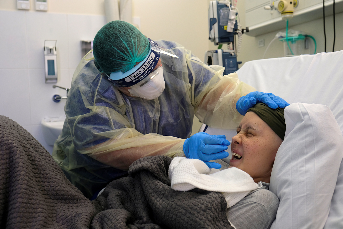 Una enfermera protegida con mscara facial la somete a un test.
