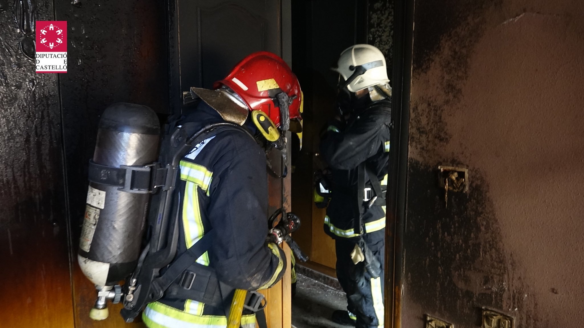 Bomberos apagando un incendio en una vivienda.
