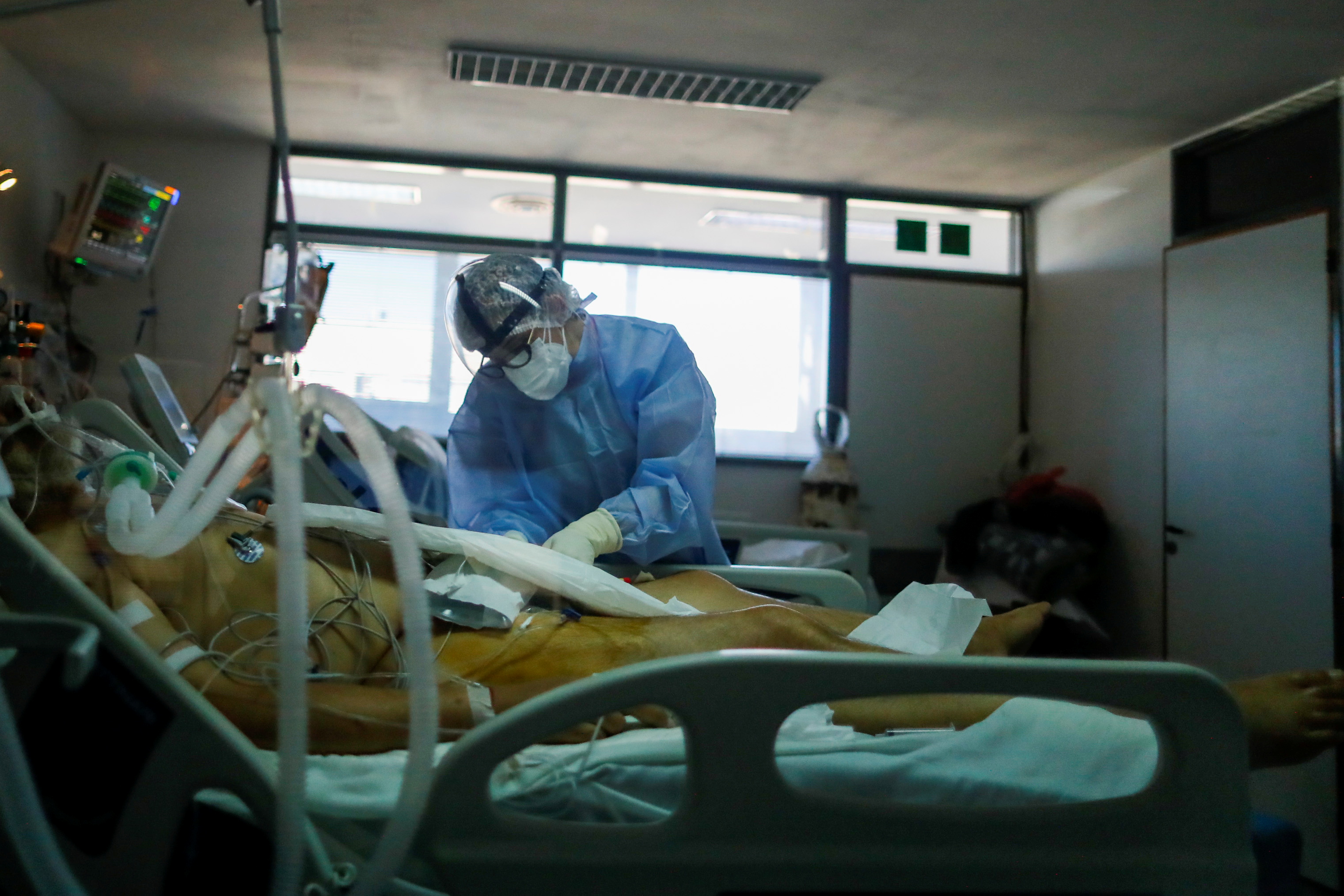 Trabajador sanitario atiende a un ingresado por Covid en Buenos Aires.