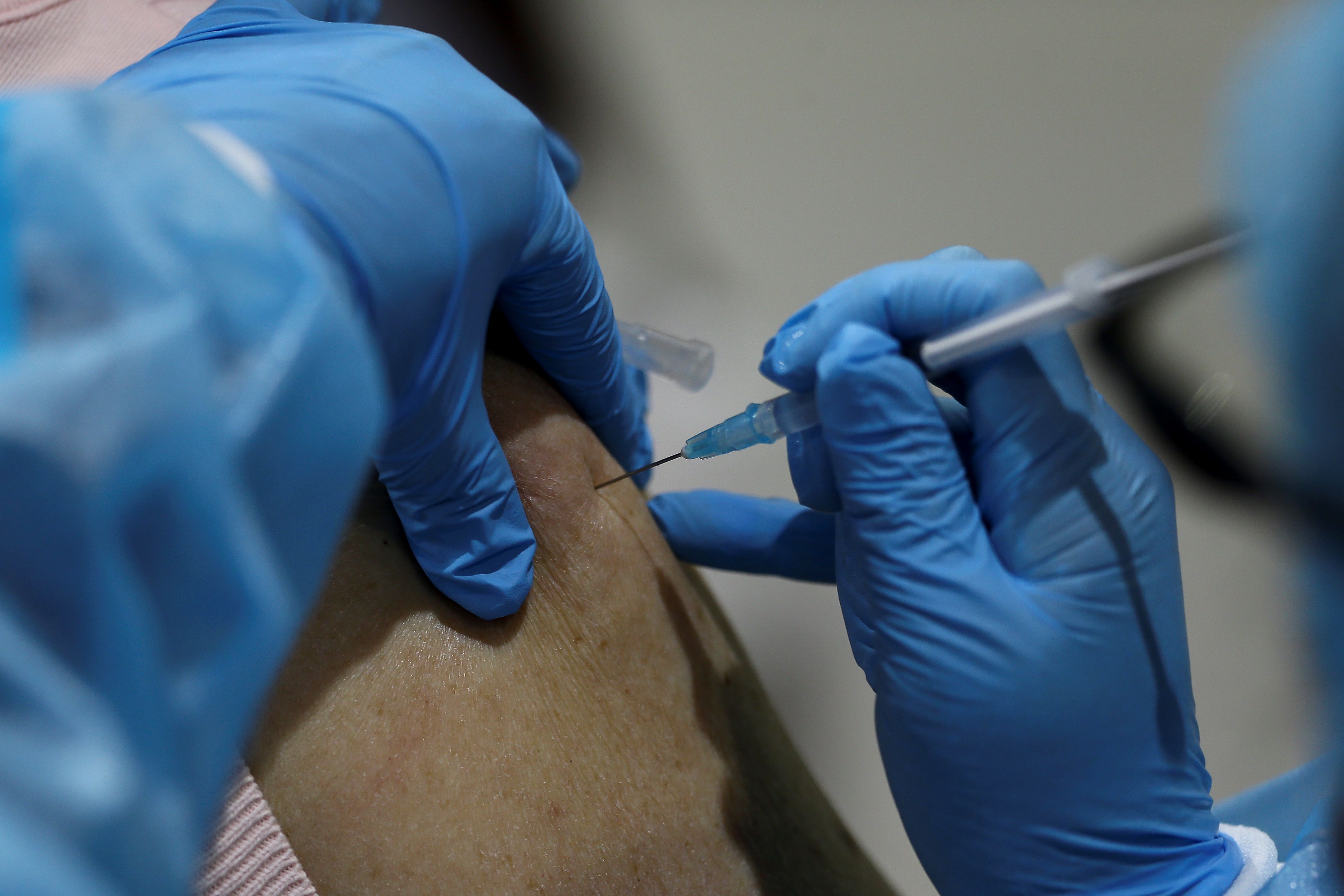 Un sanitario administra una vacuna contra la Covid en Quito (Ecuador).