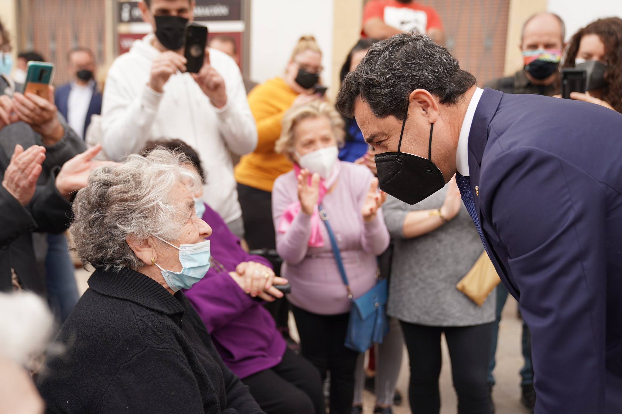 El presidente andaluz, Juanma Moreno, saluda a una anciana en su visita esta semana a Villardompardo (Jaén).