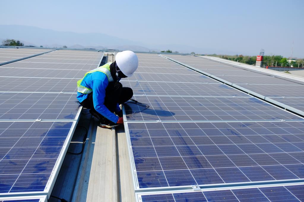 Un operario trabaja en la instalación de varias placas fotovoltaicas.
