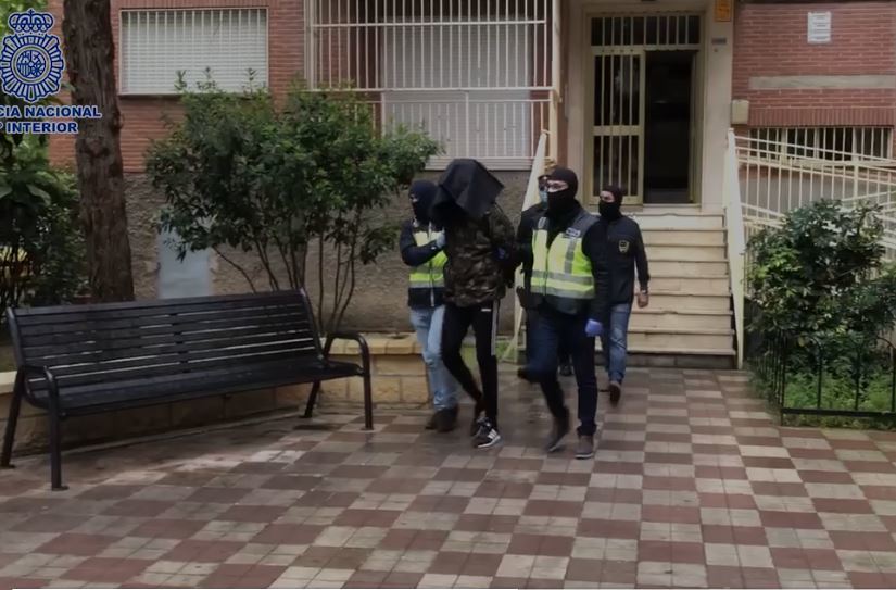 Varios agentes conduciendo a uno de los tres detenidos en Granada.